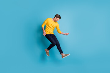 Fototapeta na wymiar Full length body size view of nice funny cool cheerful guy jumping playing invisible guitar isolated over bright blue color background