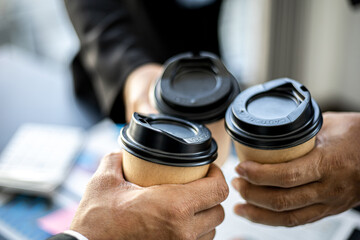 Close-up of three business men colliding with hot coffee cups after the meeting, business men gather to brainstorm ideas for business growth. Concept of business administration.