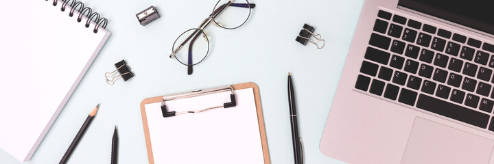 Banner with laptop and scattered stationery on a blue background. Online education workplace,...