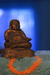 Statue of buddha, Xuangzang on carpet, light blue background 