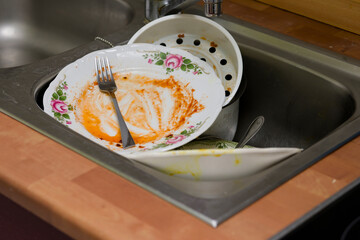 Dirty, unwashed dishes in the kitchen and sink