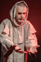 A monk in a red glow ponders the fleetingness of life