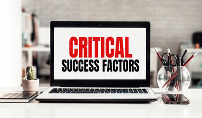 Laptop with CRITICAL SUCCESS FACTORS text on modern office background