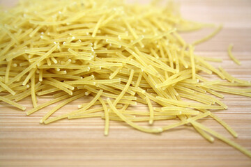 Dry wheat pasta on a wooden background.