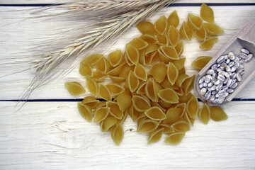 Dry wheat pasta on a wooden background.