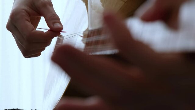 Playing Turkish Traditional String Instrument. Known as Baglama. Close Up Shot of Hands.