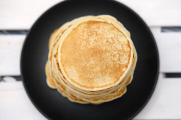 stack of classic american pancakes on a wooden rack. traditional family breakfast. comforting pancakes. top view. good morning concept. Pancake week carnival food.