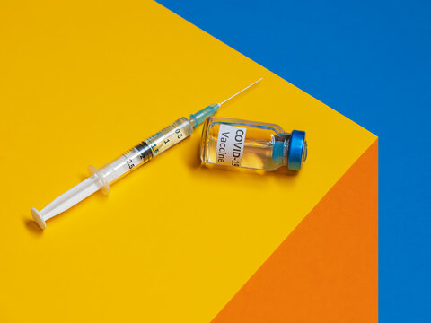 Covid-19 vaccine and syringe on a table