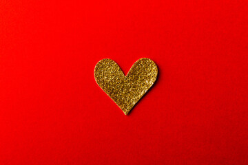 Shiny golden Heart shape sticker on red background