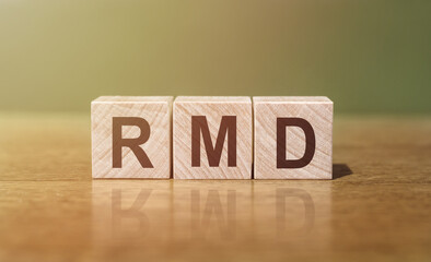 RMD - Required Minimum Distributions. Word written on wooden blocks on wooden table. Concept for...