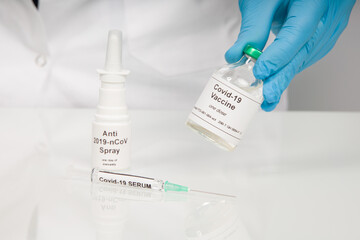 Close up of scientist's hand in medical gloves with a syringe and Covid-19 serums / vaccines