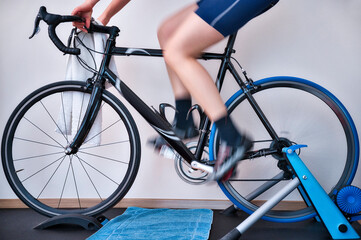 Junge Frau fährt auf dem Heimtrainer mit dem Rennrad