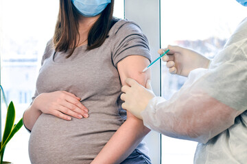 Doctor giving COVID-19 coronavirus vaccine injection to pregnant woman. Vaccination Young Pregnant Woman In Clinic. People vaccination concept. alaskapox - obrazy, fototapety, plakaty