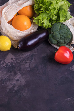 Fresh fruits and vegetables in eco cotton bags on table