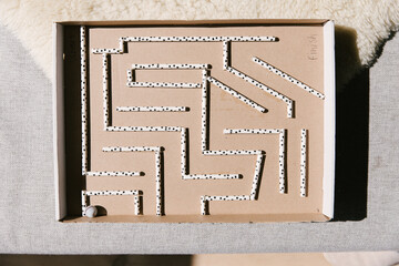 A diy marble maze made with paper straws in a cardboard box.