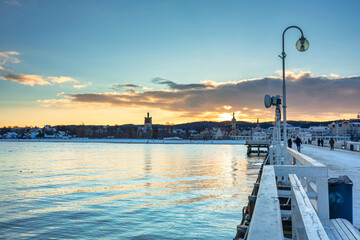 Beautiful sunset over the snowy pier (Molo) in Sopot at winter. Poland - obrazy, fototapety, plakaty