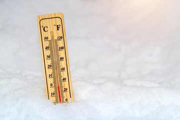 Thermometer in the snow shows zero temperature before spring
