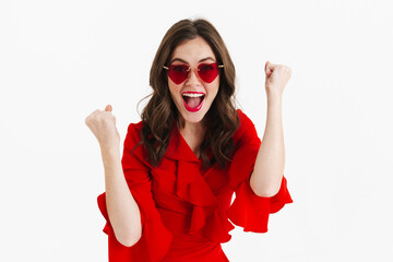 Excited beautiful girl in heart sunglasses making winner gesture