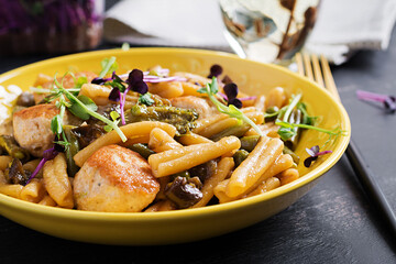 Caserecce pasta with meatballs in  sweet and sour sauce and vegetables in bowl.