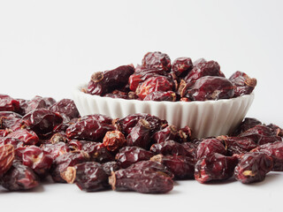 Dried berries of Dog Rose or Rosa canina. Dry fruits of sweet-brier or rose hips on wooden background. Healthy and herbal concept. Selective focus. Natural vitamin, nutritional supplement for health