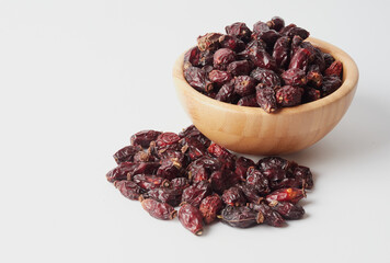 Dried berries of Dog Rose or Rosa canina. Dry fruits of sweet-brier or rose hips on wooden background. Healthy and herbal concept. Selective focus. Natural vitamin, nutritional supplement for health