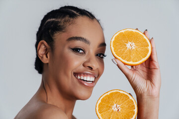 Happy shirtless african american woman posing with orange