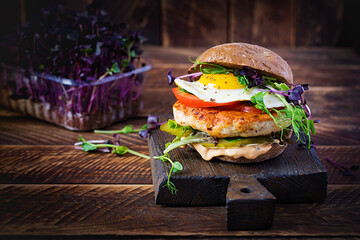 Hamburger. Sandwich with chicken burger, tomatoes,  pickled cucumber and fried egg. Fresh tasty...