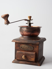 Photo of an antique hand wooden coffee grinder isolated on a white background. vintage style. retro manual coffee mill