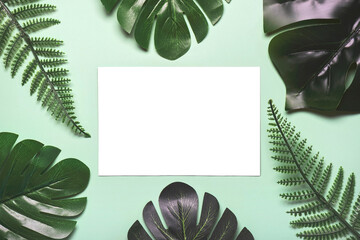 Tropical palm leaves frame with white paper in the center