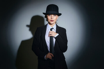 attractive young woman in a man's suit and a fedora. retro style photo shoot
