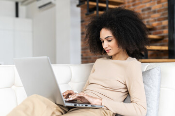 Young mixed-race female businesswoman or female freelancer with Afro hairstyle in comfy casual...