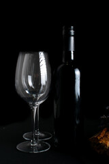 Wine glasses and black bottle of wine on dark background