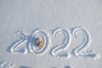 Inscription 2022 on snow.  Year of the tiger, soft toy tiger. New Year's date concept. Top view. Copy space.