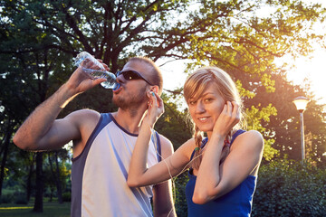 Fototapeta premium Two young sporty man and woman exercising in park at summertime season.