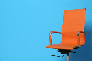 Comfortable office chair on light blue background, space for text