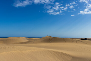 Fototapeta na wymiar Couple walking through Gran Canaria desert dunes