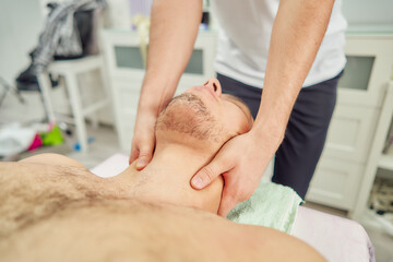 A man on a massage table receives a treatment from a professional.