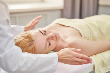 Fototapeta na wymiar Hygienic facial massage. Relaxing procedures for a woman in a spa salon.