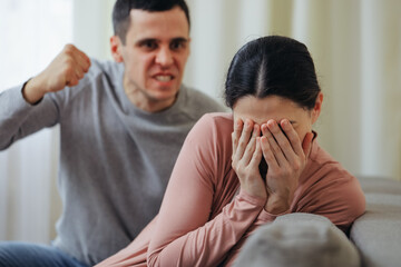 The alcoholic husband beats his wife with his fist.