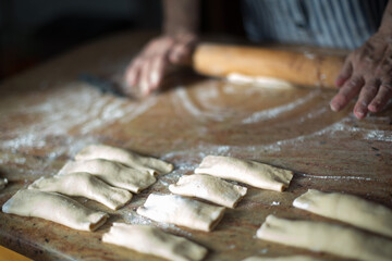 Typical asturian Christmas dessert. Aged woman's hands with a rolling pin preparing at home...