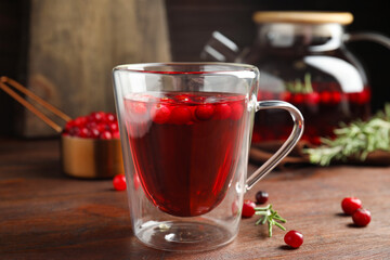 Tasty hot cranberry tea on wooden table