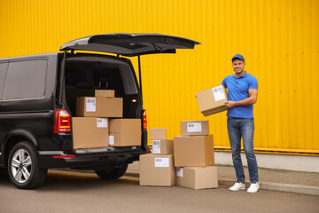 Courier with parcels near delivery van outdoors