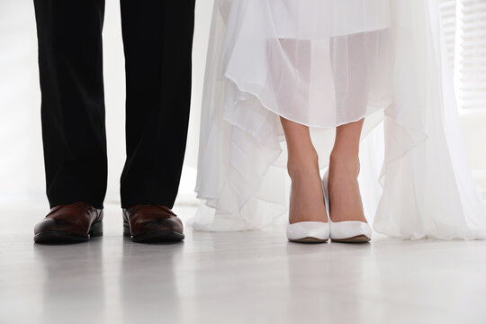 Bride and groom wearing elegant classic wedding shoes indoors, closeup