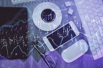 Multi exposure of forex graph hologram over desktop with phone. Top view. Mobile trade platform...