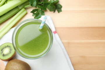 Glass of fresh celery juice on wooden table, flat lay. Space for text