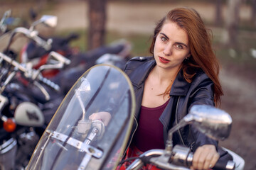 Obraz na płótnie Canvas Biker girl with long hair sits on a motorcycle.