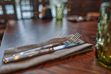 Close-up of cutlery on a linen napkin on a restaurant dining table.