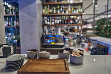 Porcelain saucers and bowls with sugar for tea with a wooden tray at the bar.
