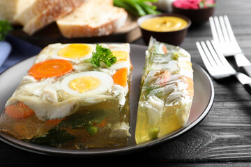 Delicious fish aspic served on black wooden table, closeup