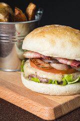 Bacon, cheese, tomato, onion and lettuce burguer with fried potatoes